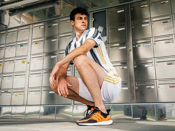 Modele en tenue Adidas devant architecture urbaine