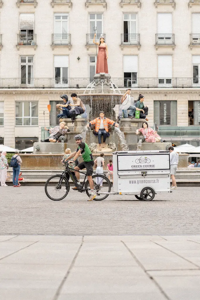 Livreur Green Course à vélo Place Royale à Nantes devant la fontaine